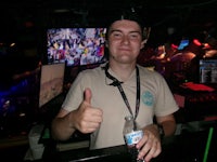 a man giving a thumbs up in a bar